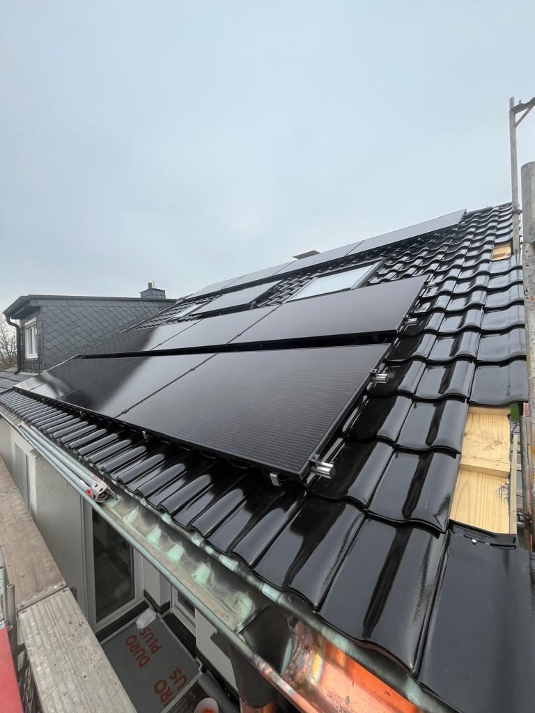 Schwarze Photovoltaikmodule auf dunklem Ziegeldach